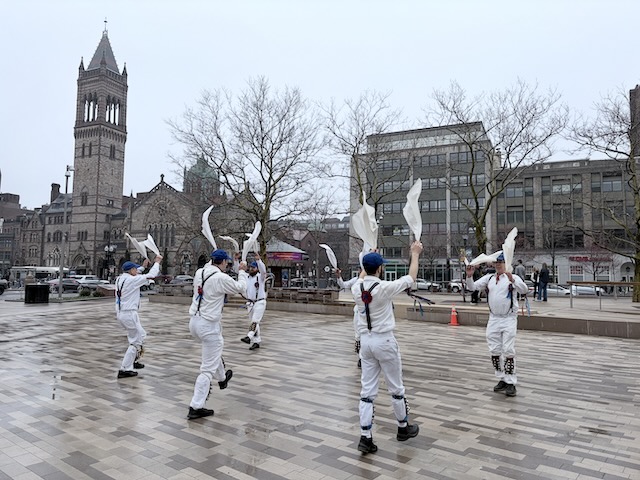 Newtowne Morris performing Fieldtown Dearest Dickie on Copley Plaza across from Old South Church, two lines of dancers in whites, suspenders, and blue caps facing each other and waving their hankies.